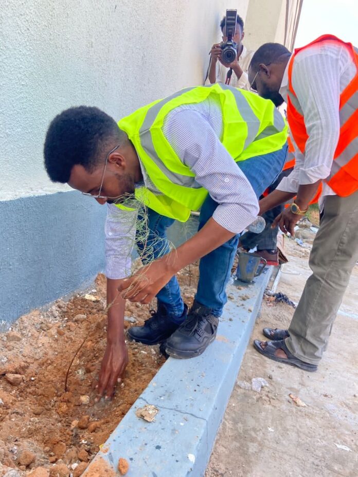 Photo shows Abdirahman Ali Mohamud (front) planting a tree on 21 March 2023 marking the International Forest Day.