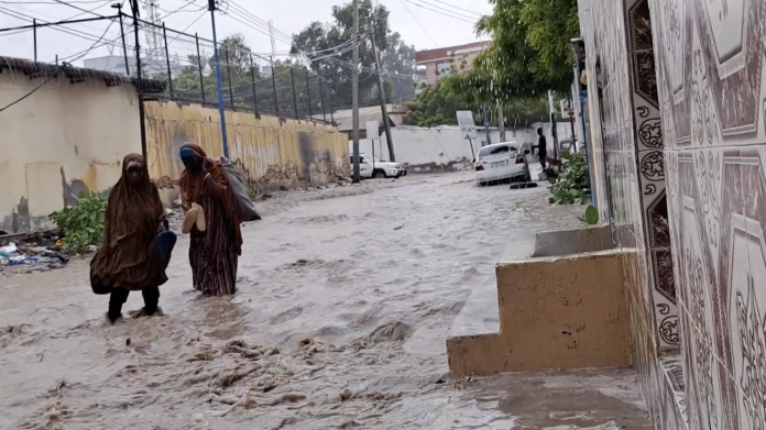 Women walk through flooded road in Mogadishu Wednesday