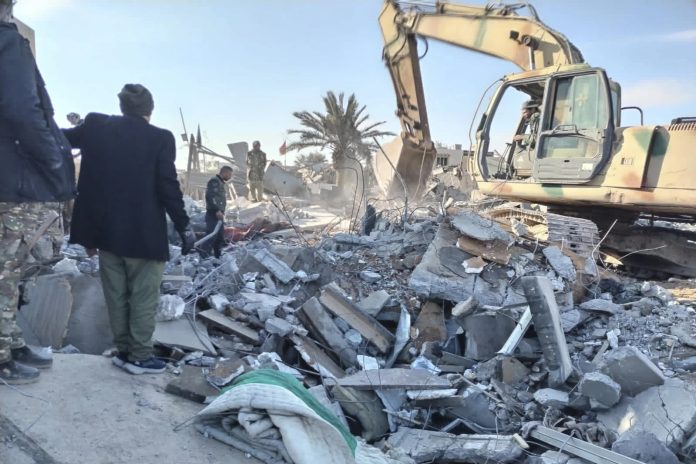 Members of Iraqi Shiite Popular Mobilization Forces clean the rubble after a U.S. airstrike in al-Qaim, Iraq, Saturday, Feb. 3, 2024. The U.S. Central Command said in a statement on Friday that the U.S. forces conducted airstrikes on more than 85 targets in Iraq and Syria against Iran’s Islamic Revolutionary Guards Corps and affiliated militia groups. (AP Photo/Popular Mobilization Forces Media Office).