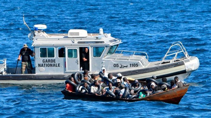 Migrants of African origin trying to flee to Europe crammed on board of a small boat as Tunisian coast guards prepare to transfer them onto their vessel at sea between Tunisia and Italy on August 10, 2023. PHOTO | AFP.