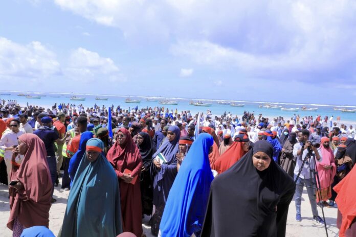 Mourners gather at Liido beach on Monday following the terror attack at the beach that killed at least 50 innocent civilians.