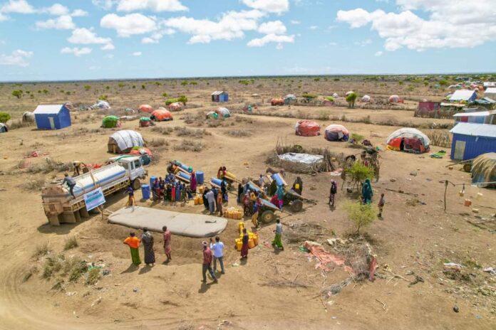 People gather to receive water at a diplaced community Kismayo town, Southern Somalia region of Jubbaland. | PHOTO/Kaab TV,